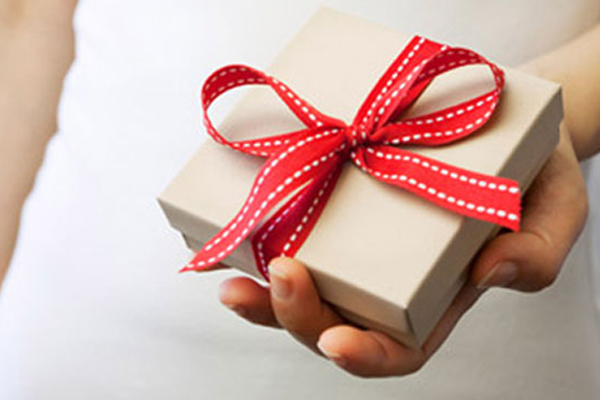 Woman holding a box tied with red ribbon