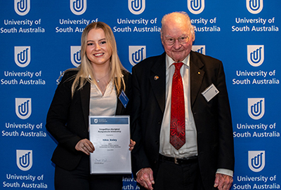 Nikia receiving the Yangadlitya Aboriginal Postgraduate Scholarship from Dr Lewis O'Brien AO FUniSA